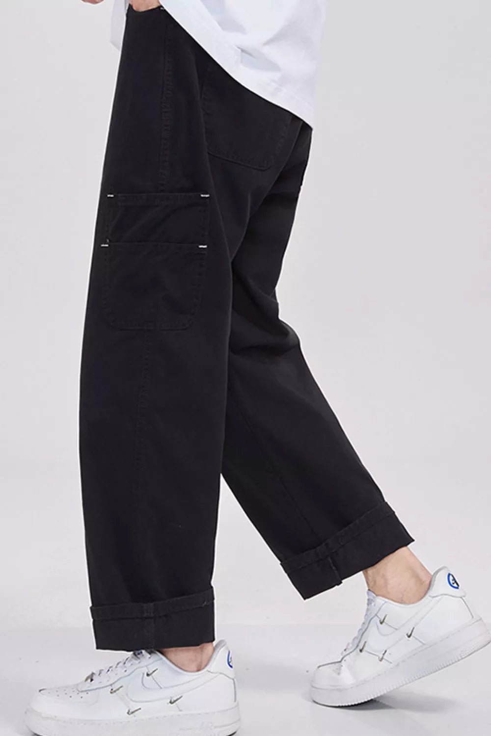 Relaxed fit black cargo sweatpants with cuffed hems and visible stitching detail on pockets.