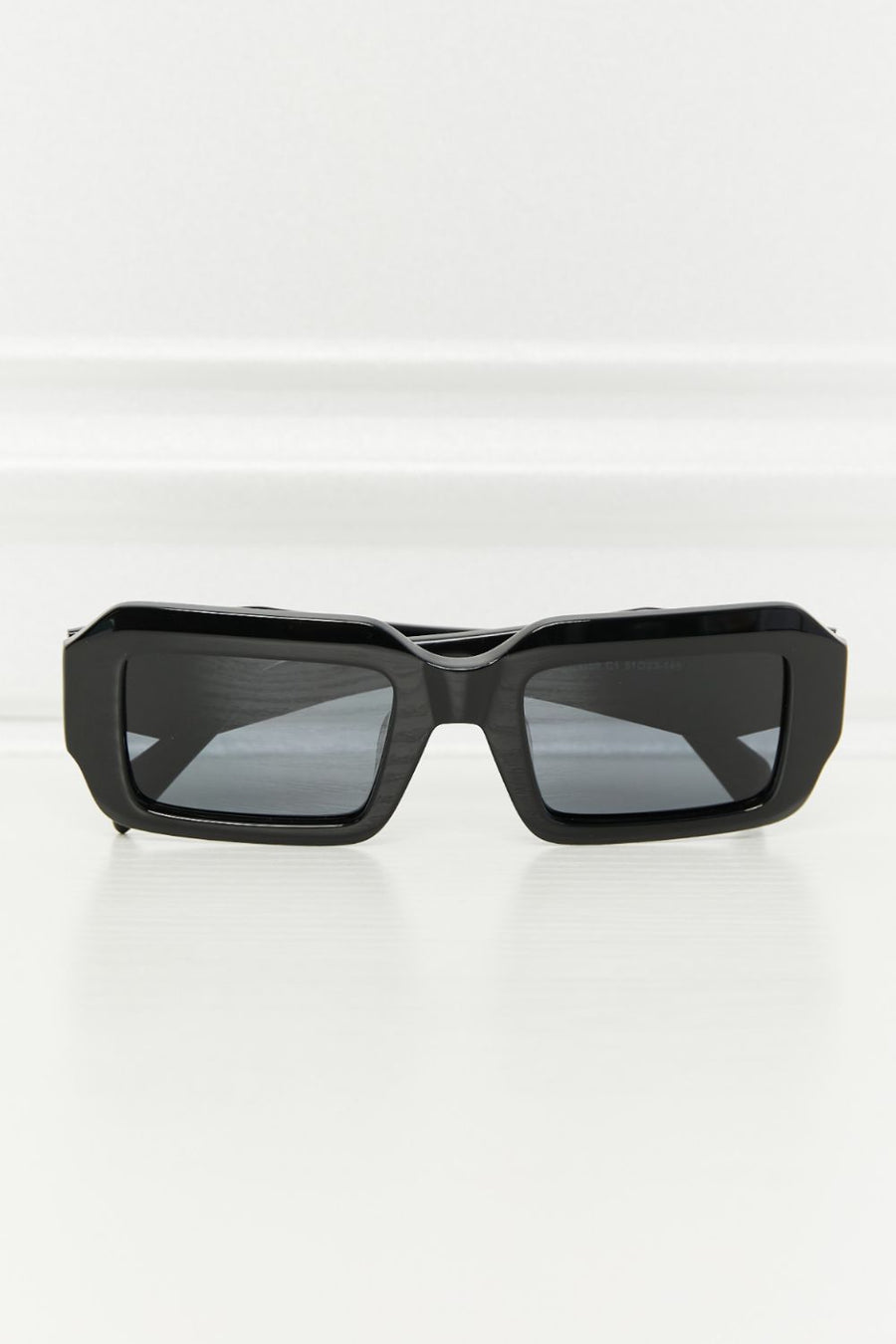 Black geometric frame polarized sunglasses with acetate material.