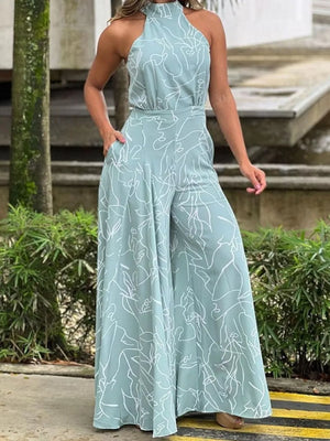 Light blue halter neck romper with abstract white line print and wide legs.