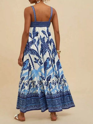 Maxi swim dress with tropical parrot print, square neck, tiered skirt, and blue trim.