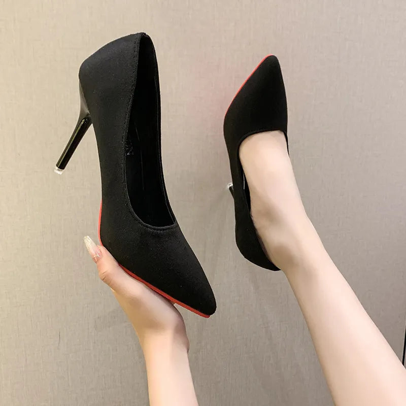 Black pointed stiletto pumps with crimson soles and a sleek heel.