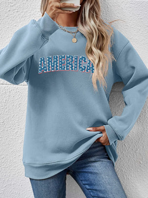 Misty Blue graphic crewneck sweatshirt with AMERICA text in stars and stripes pattern.