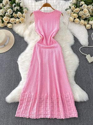 Pink knit midi dress with textured pattern, pearl trim, and cutout details.
