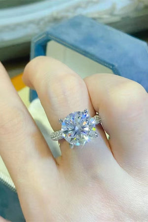 Silver pavé band round moissanite solitaire ring with a large center stone.