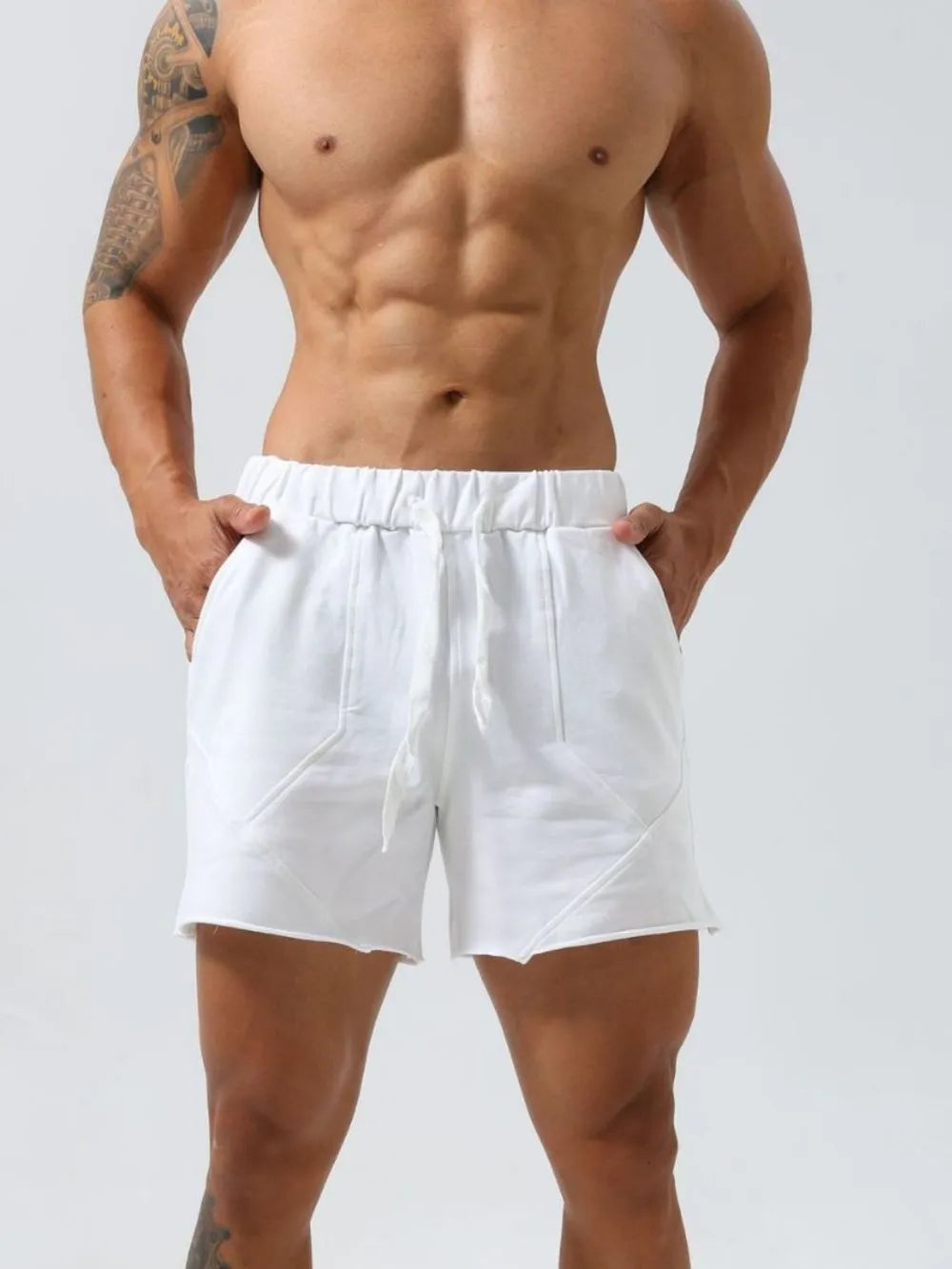 White lounge shorts with raw-edge seams and drawstring waist.