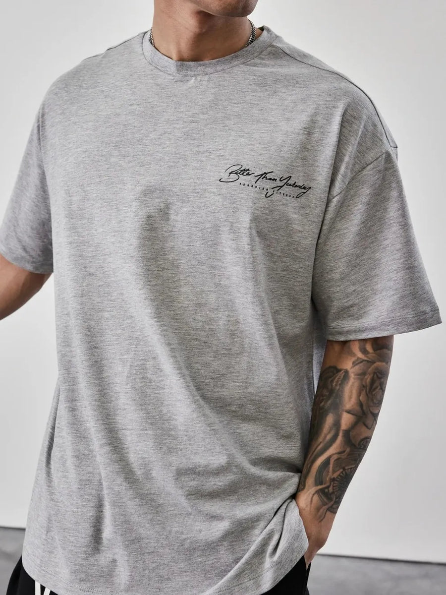 Oversized gray graphic tee with black script print on chest.