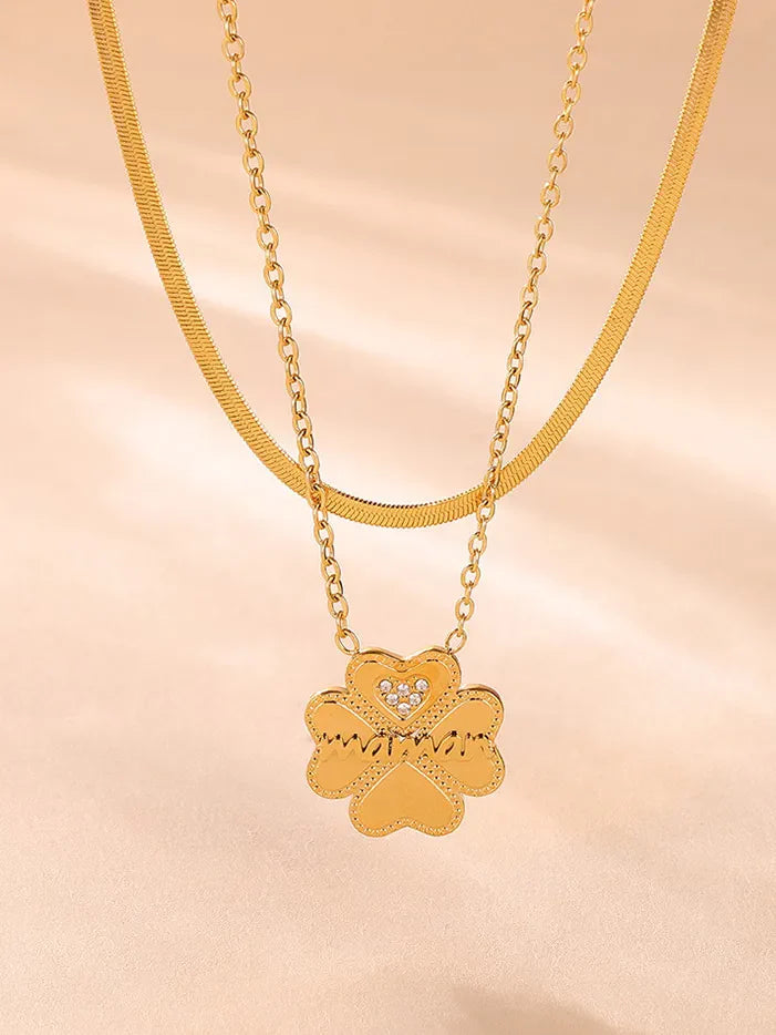 Gold layered necklace with clover charm and heart detail.