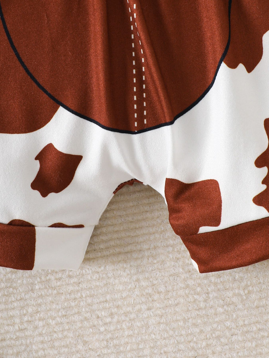 Baby bodysuit and shorts set with brown and white cow print, featuring contrast stitching detail.