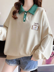 Textured waffle-knit polo sweatshirt in apricot with green collar and button placket.