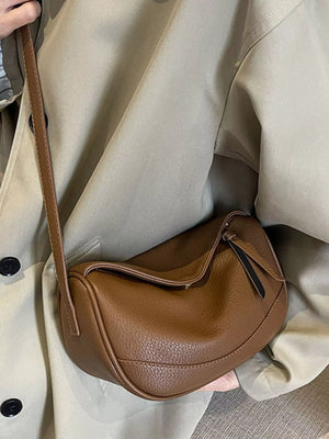 Brown pebbled leather crossbody bag with a flap closure and adjustable strap.