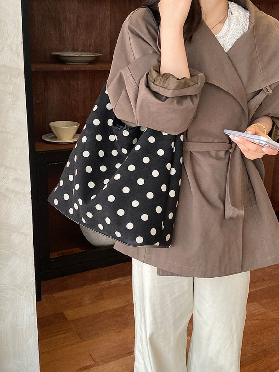 black handbag featuring pocketed and polka-dot