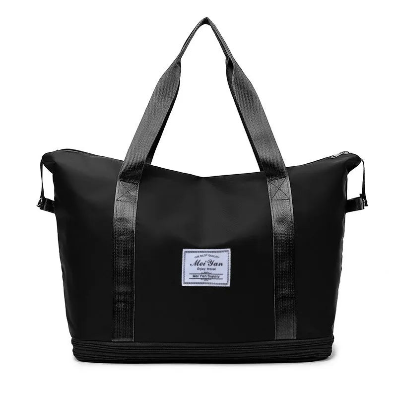 Black expandable travel tote with contrast trim and dual top handles.