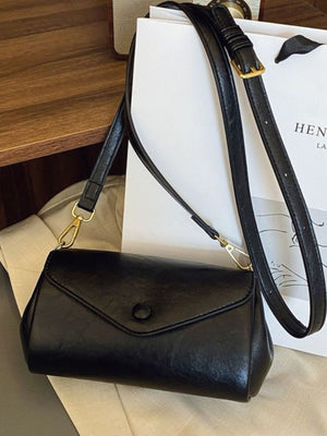 Black mini pu leather flap crossbody bag with gold hardware and adjustable strap.