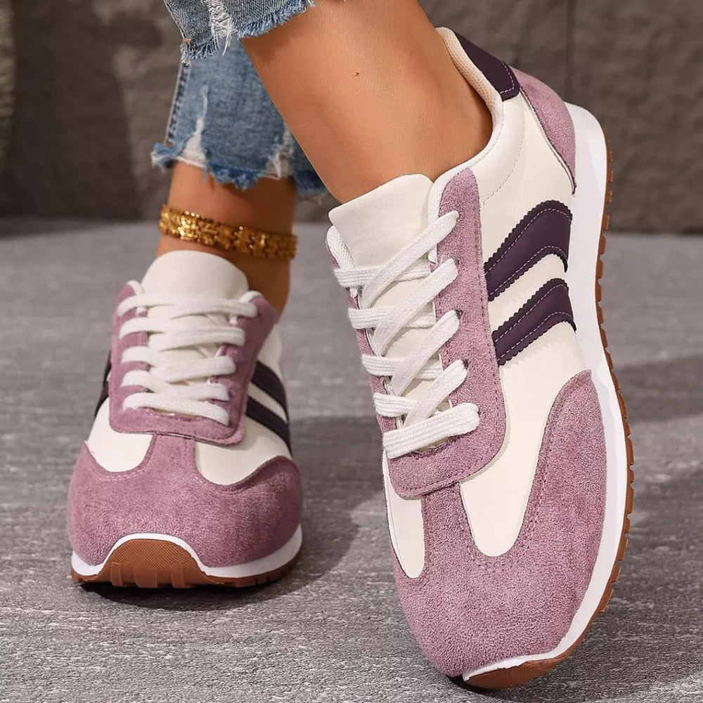 Two-tone suede lace-up sneakers in pink purple with white laces and purple stripes.