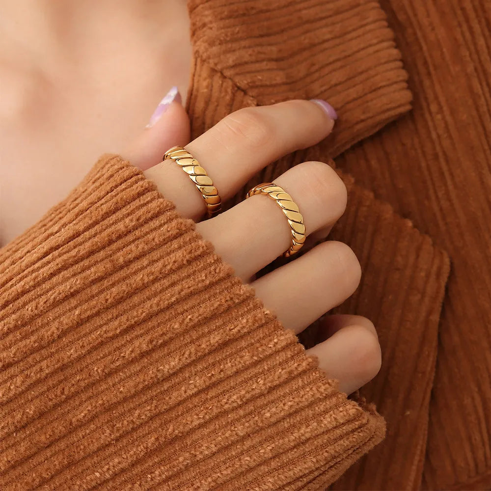 Gold braided titanium band ring with a textured, twisted design.