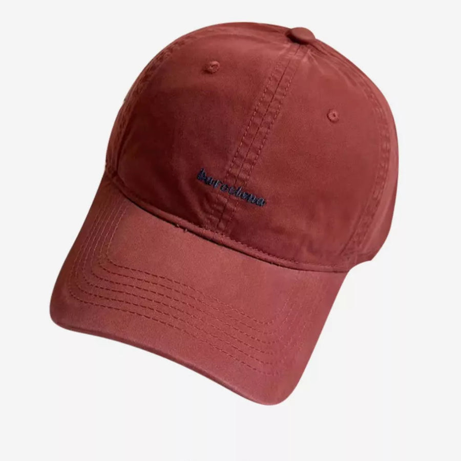 Red baseball cap with embroidered text and stitched details