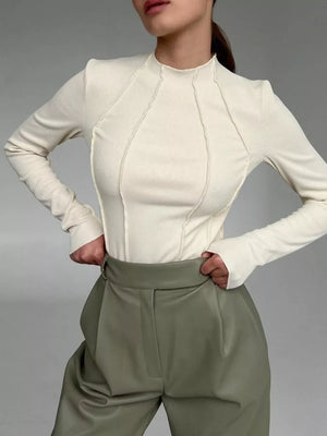 Apricot seam-detail mock neck t-shirt with long sleeves and deconstructed stitching.