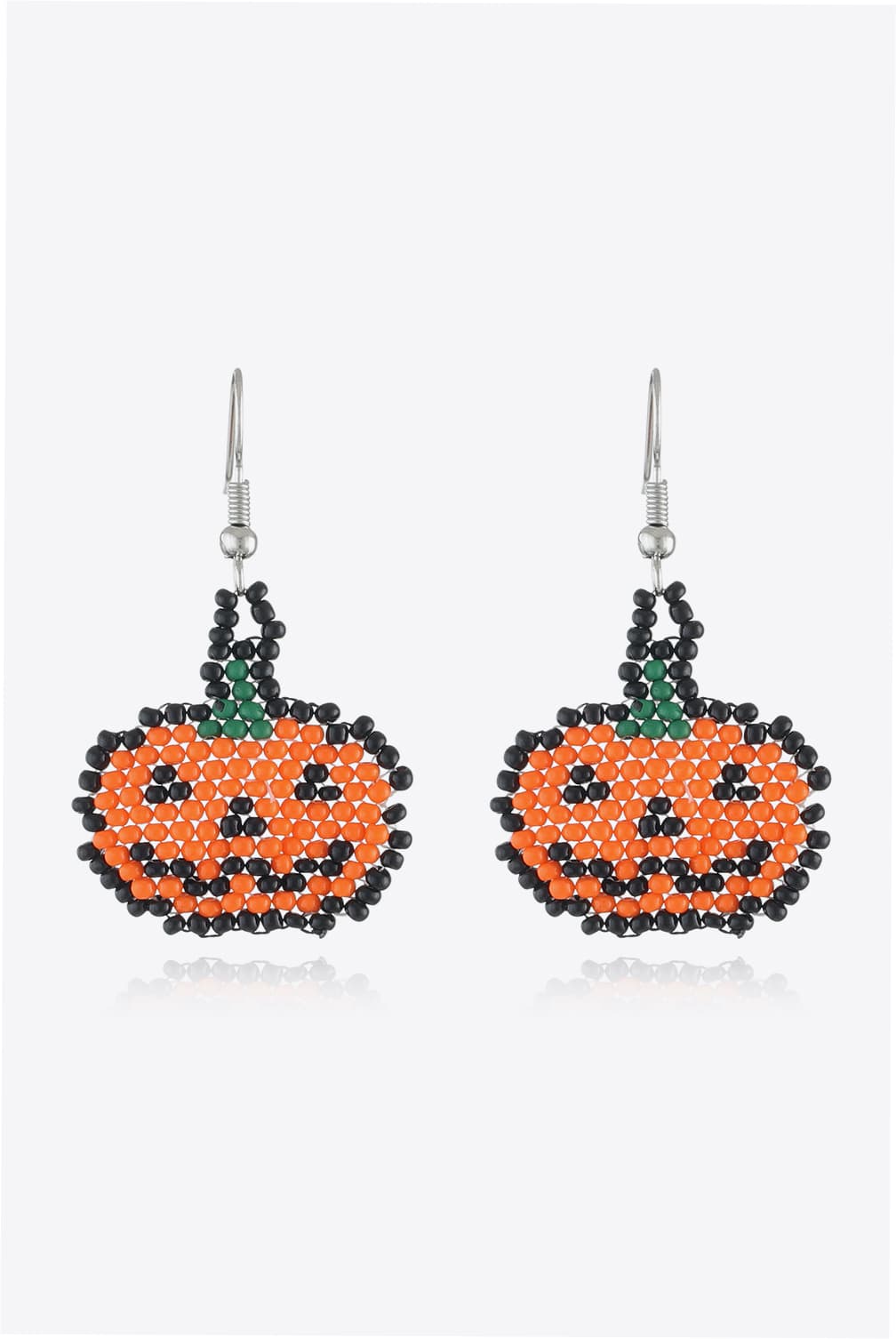 Beaded pumpkin earrings in orange and black with green stems.