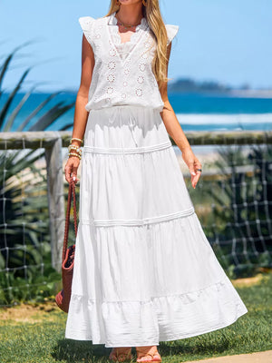 White tiered maxi skirt with drawstring waist and ruffled hem, styled with a white eyelet top.