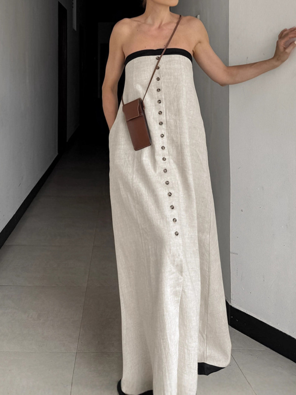 Button front tube maxi dress in beige cotton blend with black trim.