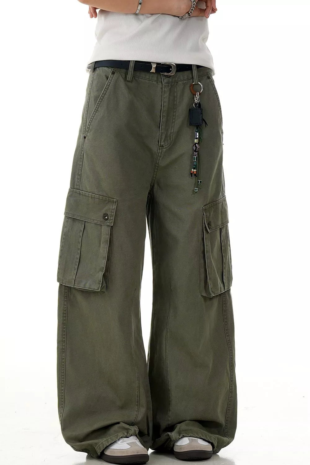 Olive green wide-leg cargo pants with multiple pockets and a beaded keychain accessory.