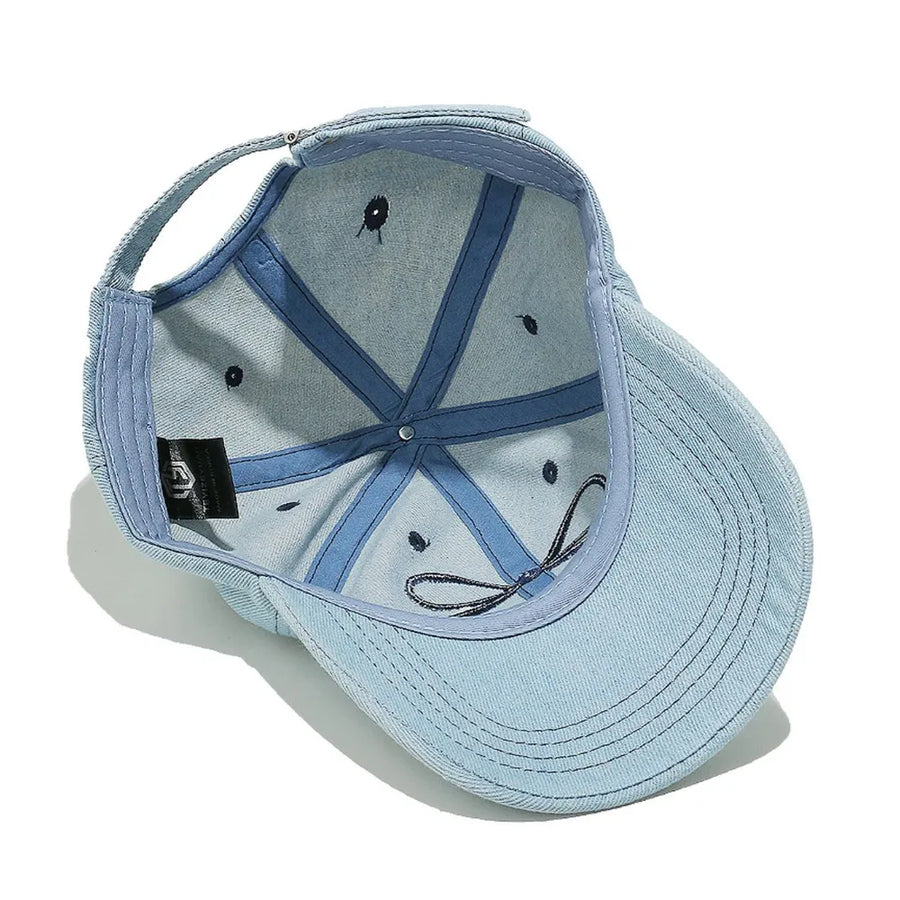 Light blue denim baseball cap with embroidered bow detail and adjustable strap.