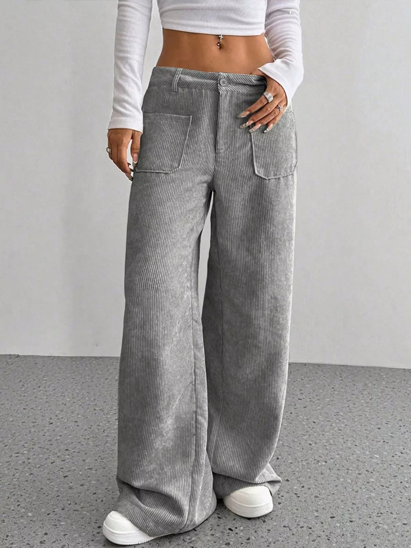 Grey corduroy wide-leg trousers with front pockets and a comfortable fit.