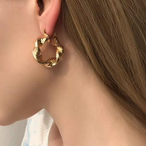 Gold textured hoop earrings with a twisted design, perfect for women.
