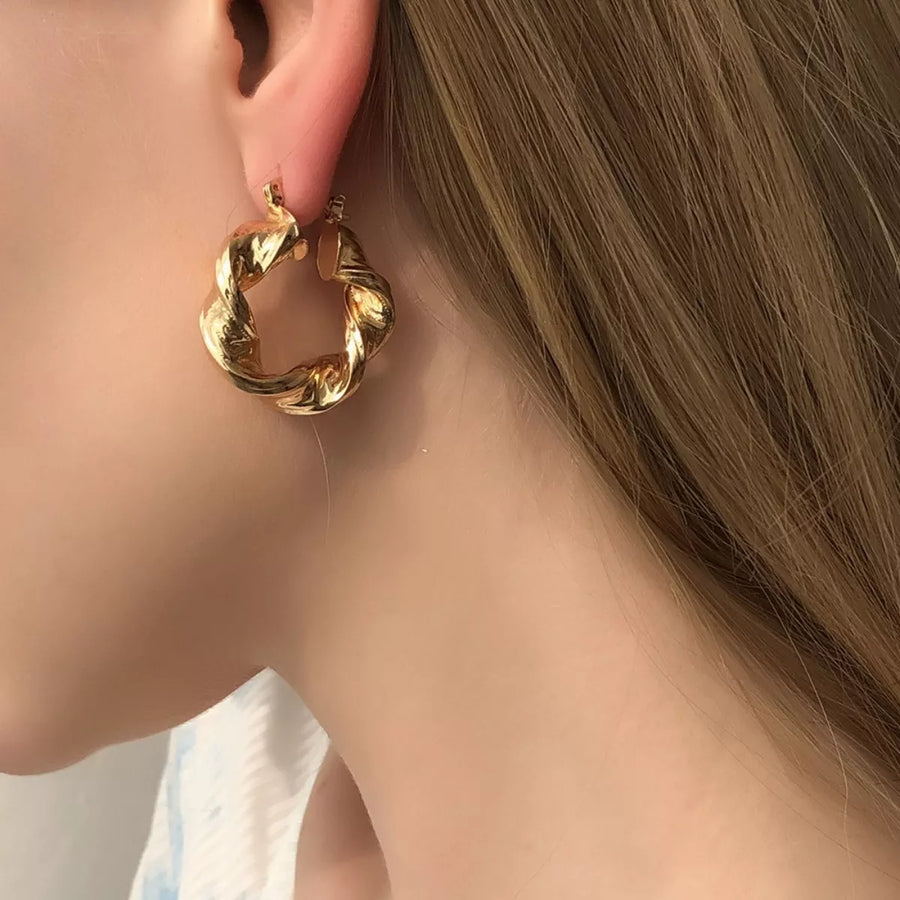 Gold textured hoop earrings with a twisted design, perfect for women.
