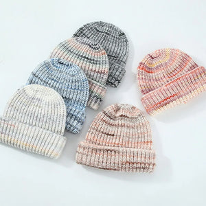 Textured mélange ribbed beanie in cream, gray, blue, and burnt coral colors.