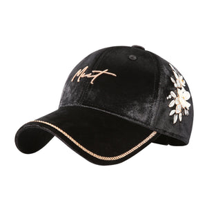 Black velvet baseball cap with embroidered floral detail and braided rope trim