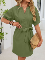 Army green cotton dress with notched V-neck, short puff sleeves, button front, and tie waist.