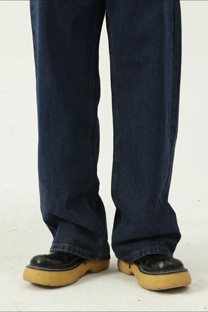 Baggy dark wash denim jeans with a wide leg silhouette, styled with chunky platform shoes.