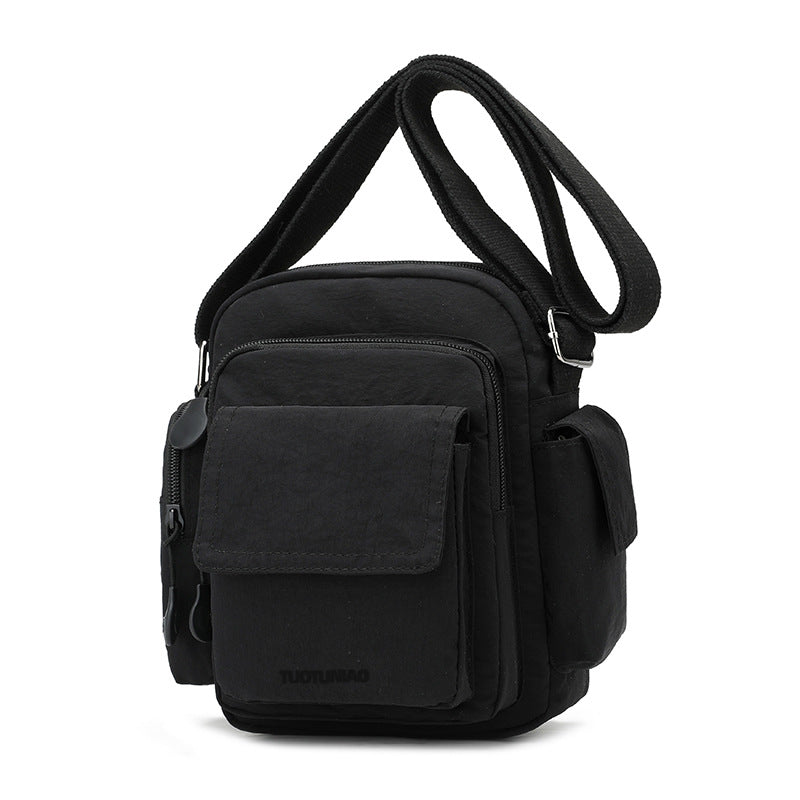 Black lightweight nylon crossbody bag with multiple exterior pockets and adjustable strap.