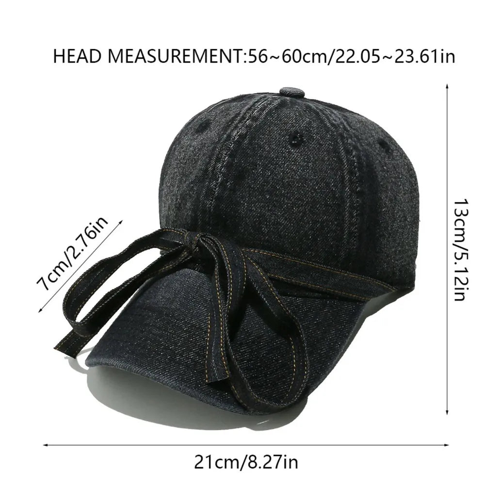 Denim baseball cap in black with a decorative bow tie detail.