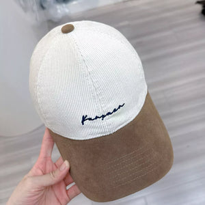 Two-tone corduroy baseball hat in Milky White and Camel with embroidered detail.