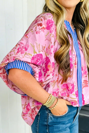Pink floral v-neck blouse with blue striped cuffs and placket accent