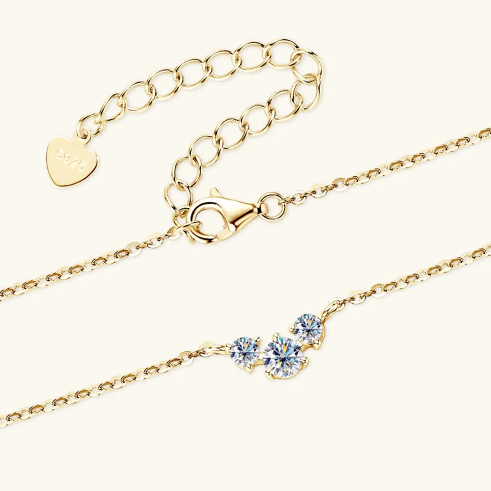 Gold cluster pendant necklace with three round D color moissanite stones and adjustable chain.