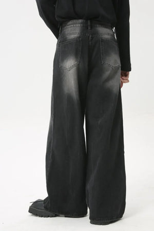 Whiskered wide leg denim jeans in dark wash, featuring a relaxed fit and distressed details.