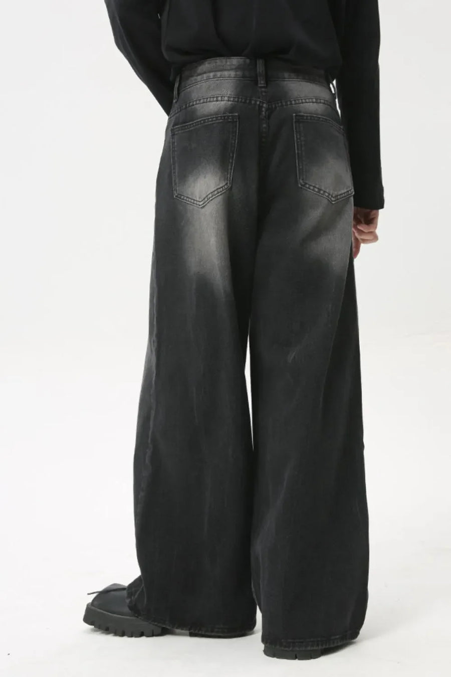 Whiskered wide leg denim jeans in dark wash, featuring a relaxed fit and distressed details.