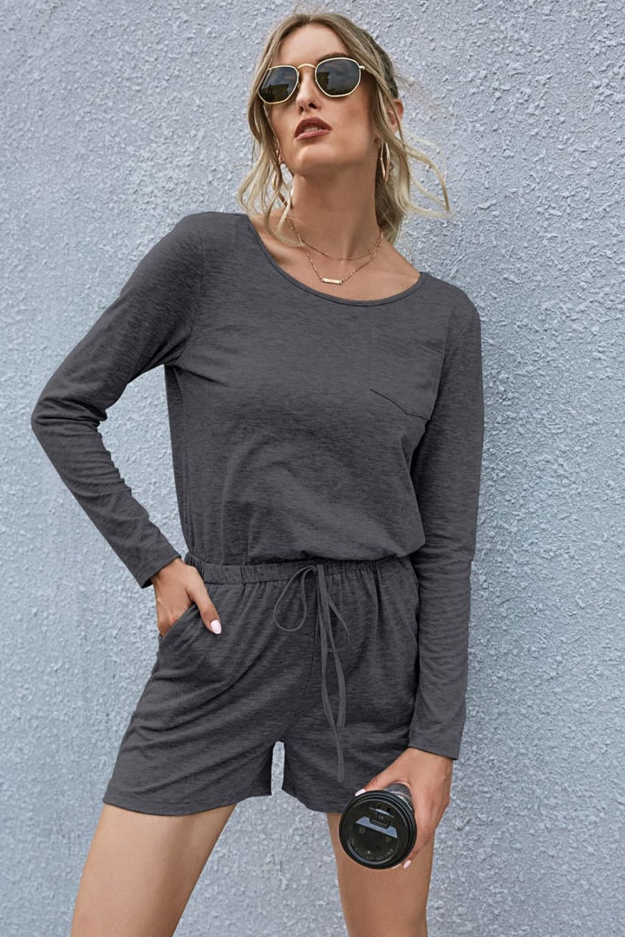 Dark gray jersey pocket romper with long sleeves, drawstring waist, and shorts.