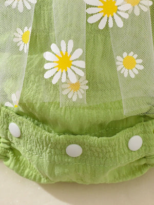 Green baby bodysuit dress with daisy embroidery and tulle overlay, featuring snap closures.