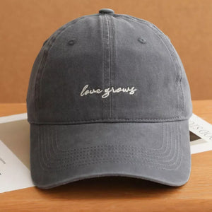 Grey cotton baseball cap with white "love grows" embroidery