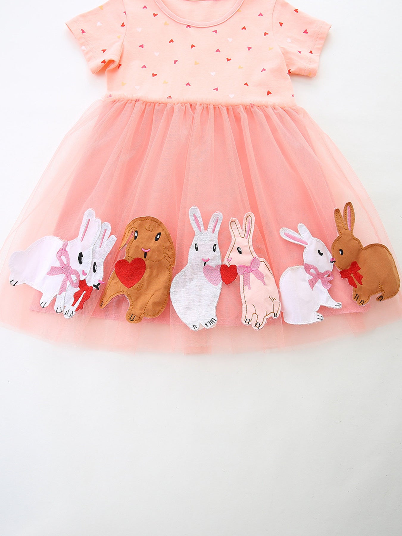 Pink tulle baby dress with heart print top and bunny applique hem.