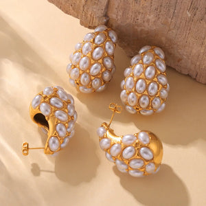 Gold sculptural earrings with pearl clusters, showcasing a unique textured design.