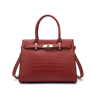 Burgundy crocodile-embossed medium tote handbag with gold hardware and top handles.