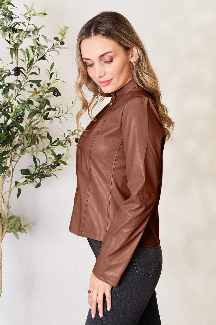 Biker jacket in Dark Camel faux leather with a stand collar and zip closure.
