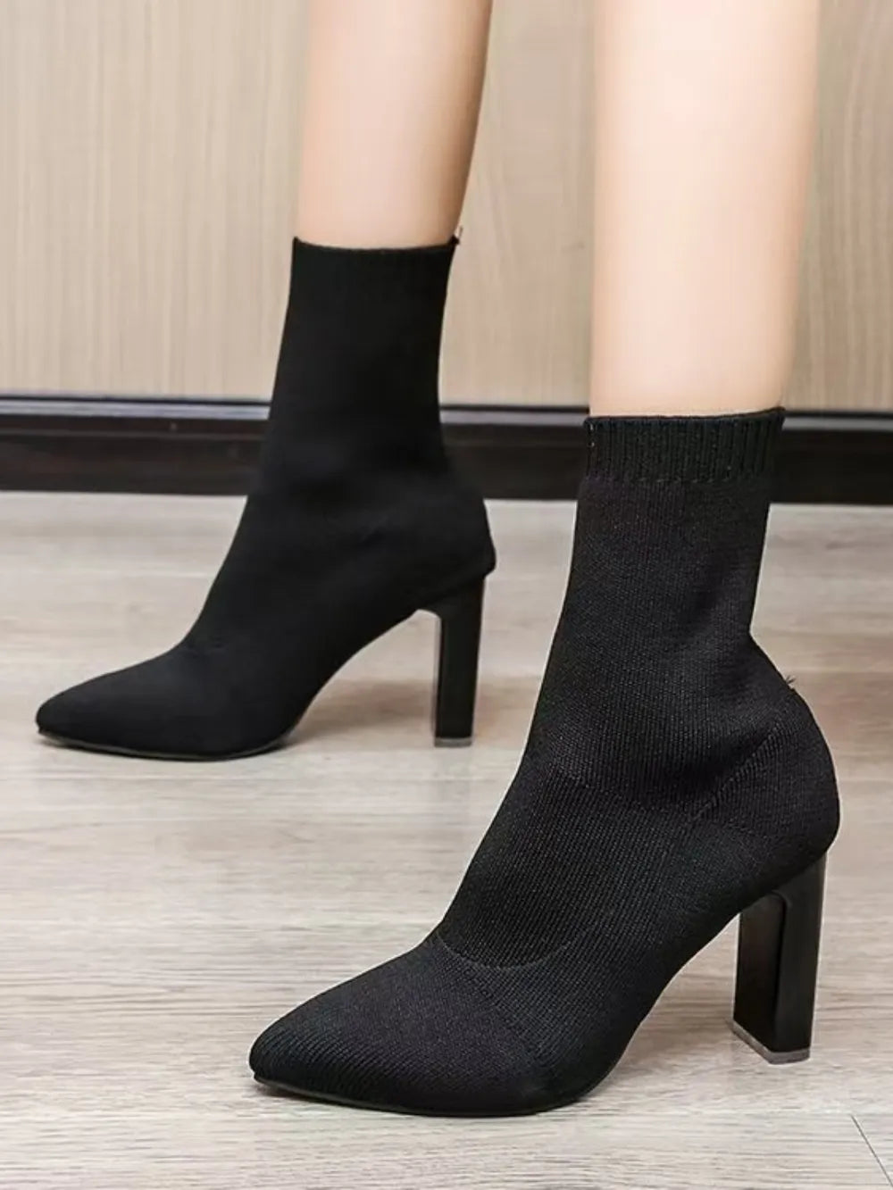 Black knit sock booties with pointed toe and sculpted block heel.