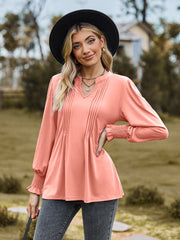 Peach pleated yoke blouse with shirred cuffs and V-neck.