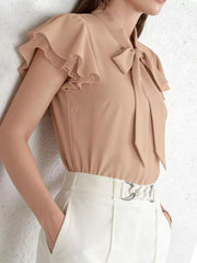 Tan tie-neck blouse with ruffle lace sleeves and a bow detail.